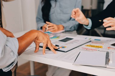 Mali Danışmanlık Servisi ekibi. Danışmanlık bürosundaki müşterilere yatırım planını gösteren Asyalı danışman.