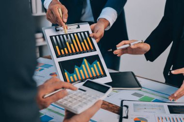 Muhasebe şirketi kazançlı nakit akışı için finansman ve vergilendirme planlaması, ofiste çalışan denetçi ve muhasebeci ekibi, mali verileri ve muhasebe kayıtlarını hesap makinesiyle analiz eder.