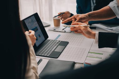 Mali Danışmanlık Servisi ekibi. Danışmanlık bürosundaki müşterilere yatırım planını gösteren Asyalı danışman.