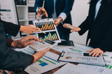 Muhasebe şirketi kazançlı nakit akışı için finansman ve vergilendirme planlaması, ofiste çalışan denetçi ve muhasebeci ekibi, mali verileri ve muhasebe kayıtlarını hesap makinesiyle analiz eder.