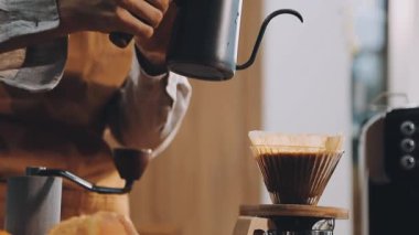 Kahve bardağına kahve dolduran baristayı kapat..