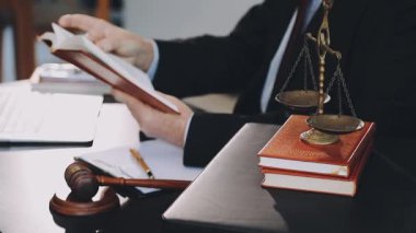 Bir tokmak ve dizüstü bilgisayarla masada çalışan bir iş adamı.