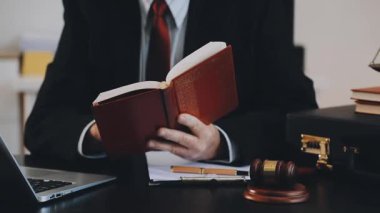 Ofiste dizüstü bilgisayar ve kitapla çalışan iş adamı.