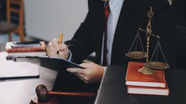 Belgeler ve terazilerle çalışan avukat, tokmak