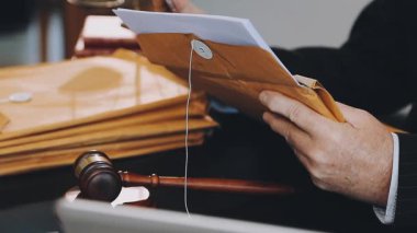 Elinde tokmak tutan takım elbiseli bir avukat.