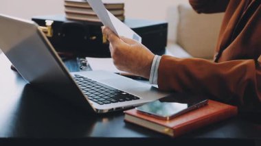 İş adamı bilgisayar kullanıyor ve elinde kalem tutuyor.