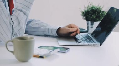 İş adamı evde dizüstü bilgisayar ve cep telefonuyla çalışıyor.