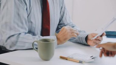 Bilgisayarlı bir iş adamı ve arka planda belgeleri var.