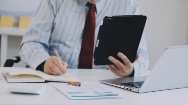 Modern bir ofiste dizüstü bilgisayarla çalışan iş adamları..