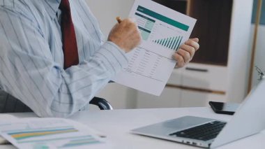 Ofis masasında dizüstü bilgisayarda çalışan iş adamı