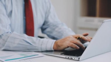 İşadamı ofiste dizüstü bilgisayarda çalışıyor.