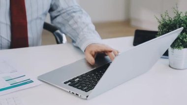 İş yerinde dizüstü bilgisayar kullanan iş adamı