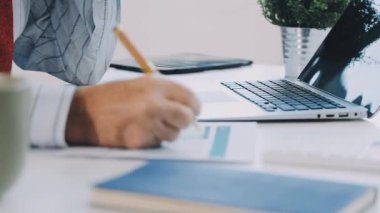 Modern ofiste finansal tablolar üzerinde çalışan iş adamları.