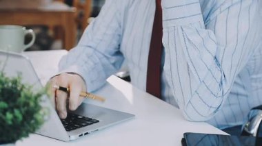 Laptop ve akıllı telefon kullanan genç işadamı