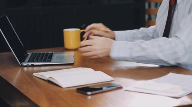 dizüstü bilgisayar üzerinde çalışan takım elbiseli adam