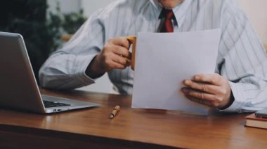 Ofisinde dizüstü bilgisayarı olan bir iş adamı.