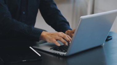 Kafede dizüstü bilgisayarı olan genç bir adam.