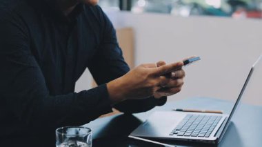 İşadamı akıllı telefon kullanıyor ve ofiste çalışıyor..