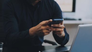 Yakın plan - ofiste dizüstü bilgisayarda yazan genç adam.