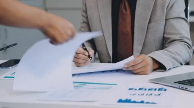 Ofiste dizüstü bilgisayar ve belgeyle çalışan işadamı