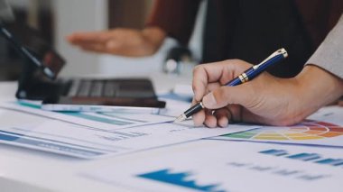 Finans belgeleri ve hesap makinesiyle çalışan bir iş kadını.