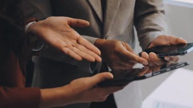 İşadamı akıllı telefon kullanıyor ve dijital tableti ofisinde tutuyor..