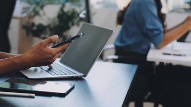 Dijital tablet kullanan genç işadamlarının yakın plan çekimleri ve ofiste modern bir dizüstü bilgisayarla çalışmaları