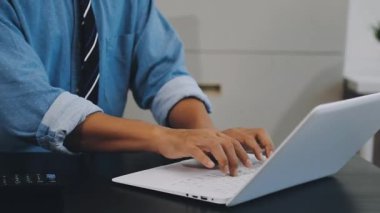 Ofiste dizüstü bilgisayar kullanan bir iş adamı.