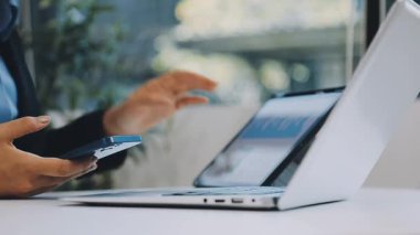 İşadamı ofiste dizüstü bilgisayar, iş teknolojisi konsepti, modern bilgisayar ve akıllı telefon ile çalışıyor.