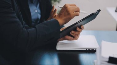 İş adamları ofiste birlikte çalışıyor ve dijital tablet kullanıyorlar..