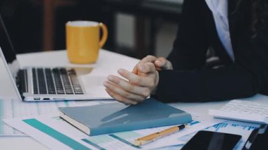 Finansal grafikleri ve dizüstü bilgisayarları tartışan iş ekibi.