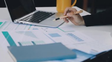 Dizüstü bilgisayarda çalışan ve verileri analiz eden iş adamı