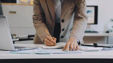 Modern ofiste dizüstü bilgisayarı olan genç bir iş kadını.