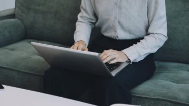 Genç iş adamı evde dizüstü bilgisayarla çalışıyor.