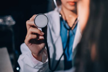 Konuşurken kalp atışı ve semptomlarını incelemek için steteskop kullanan erkek doktorun el görüntüsü.