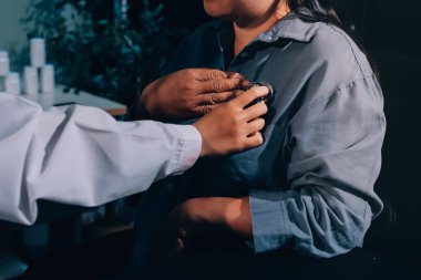 Konuşurken kalp atışı ve semptomlarını incelemek için steteskop kullanan erkek doktorun el görüntüsü.