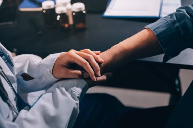 Kadın doktor ya da kadın sağlık personeli el ele tutuşarak, hastaya veya akrabalarına cesaret vererek, kadın sağlık görevlisi, doktor, terapist, tıp çalışanı kavramını benimsemiştir.