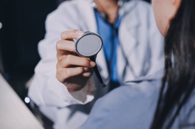 Konuşurken kalp atışı ve semptomlarını incelemek için steteskop kullanan erkek doktorun el görüntüsü.