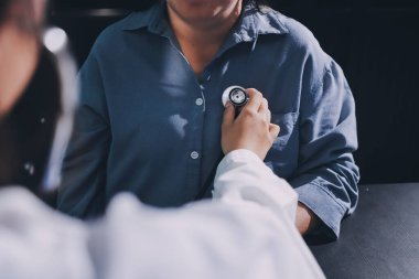 Konuşurken kalp atışı ve semptomlarını incelemek için steteskop kullanan erkek doktorun el görüntüsü.