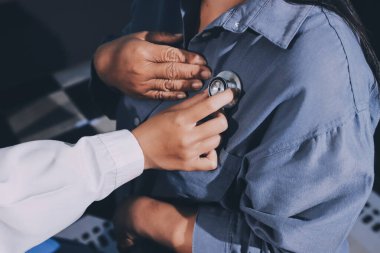 Konuşurken kalp atışı ve semptomlarını incelemek için steteskop kullanan erkek doktorun el görüntüsü.