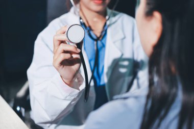 Konuşurken kalp atışı ve semptomlarını incelemek için steteskop kullanan erkek doktorun el görüntüsü.