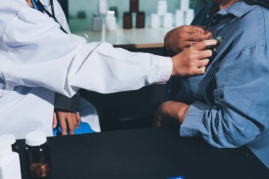 Konuşurken kalp atışı ve semptomlarını incelemek için steteskop kullanan erkek doktorun el görüntüsü.