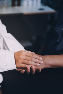 Kadın doktor ya da kadın sağlık personeli el ele tutuşarak, hastaya veya akrabalarına cesaret vererek, kadın sağlık görevlisi, doktor, terapist, tıp çalışanı kavramını benimsemiştir.