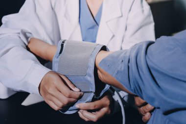 Doktorun kan basıncını ölçtüğü yakın plan.