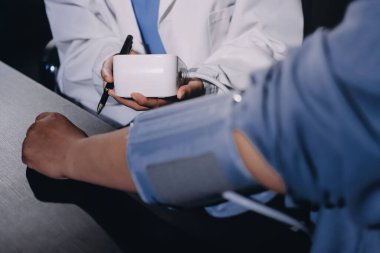 Doktorun kan basıncını ölçtüğü yakın plan.