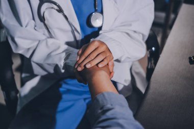 Kadın doktor ya da kadın sağlık personeli el ele tutuşarak, hastaya veya akrabalarına cesaret vererek, kadın sağlık görevlisi, doktor, terapist, tıp çalışanı kavramını benimsemiştir.