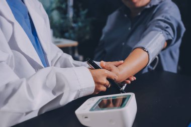 Doktorun kan basıncını ölçtüğü yakın plan.