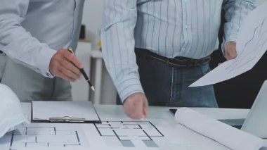 Ofiste planlar ve planlarla çalışan mühendisi kapatın..