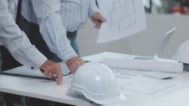 Ofiste planlar üzerinde çalışan bir mimar