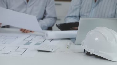Masada çalışan bir mimar. Ofisteki planlarla çalışan bir mühendis.